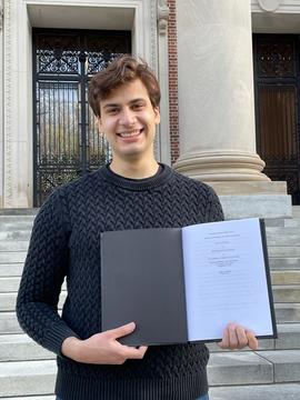 Noah DiAntonio holds a thesis on the steps of Widener Library